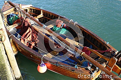 Small clinker built sailing boat moored at quayside. Stock Photo