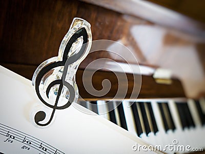 Clip in the shape of a treble clef on sheet music. Stock Photo