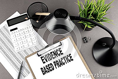 Clipboard ,chart and calculator, lamp and workspace accessories on a grey table. Top view , text EBP Evidence-based practice Stock Photo