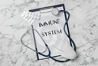 Clipboard with words Immune System, stethoscope, pills and glove on white marble table, flat lay Stock Photo