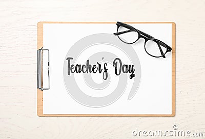 Clipboard with words TEACHER`S DAY and glasses on white wooden background, top view Stock Photo