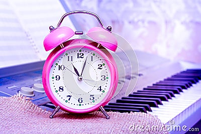 Clock against piano background. Reminder about the beginning of Stock Photo