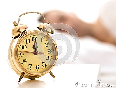 Clock close up, person sleeping in the background Stock Photo