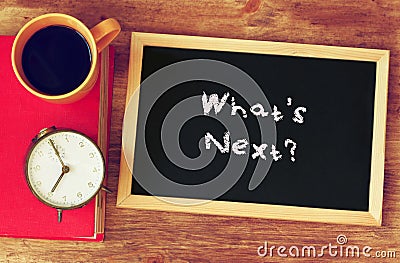 Clock, coffee, and blackboad with the phrase whats next? written on it. Stock Photo