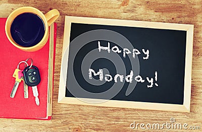 Clock, coffee cup and blackboard with the phrase happy monday! Stock Photo