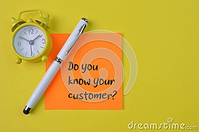 Clock, pen and memo note with question DO YOU KNOW YOUR CUSTOMER Stock Photo