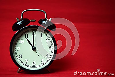 Clock ticking to 11 o`clock on the red background Stock Photo
