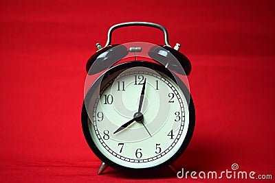 Clock ticking to 8 o`clock on the red background Stock Photo