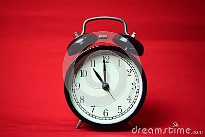 Clock ticking to 11 o`clock on the red background Stock Photo