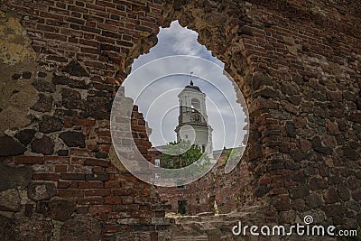 The clock tower in the opening of the wall of the destroyed cathedral. Vyborg Stock Photo