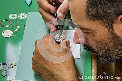 Clockmaker with loupe repair watch Stock Photo