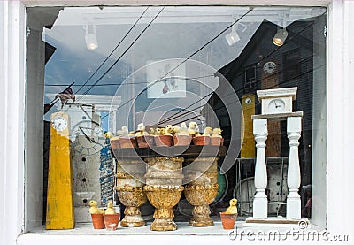 Clocks in a window - Reflections and display of antique clocks and baby ducks in flower pots in Cape Cod window with another clock Stock Photo