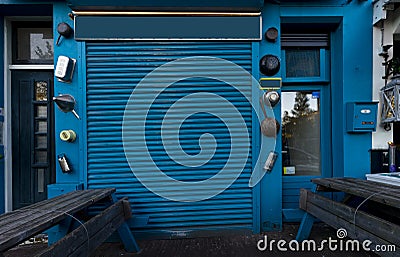 Close blue shop faÃ§ade with door and benches Stock Photo