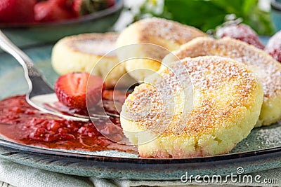 Close cheese pancakes, syrniki, curd fritters with fresh strawberries on plate background Stock Photo