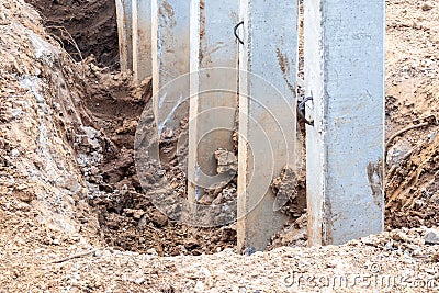 Close-concrete pillars installed in a trench dug soil Stock Photo