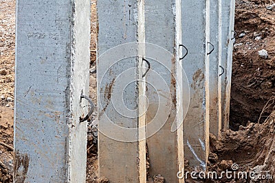 Close-concrete pillars installed in a trench dug soil Stock Photo