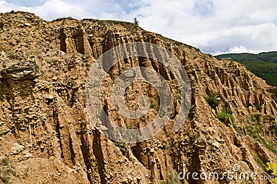 At close of the famous Stob Pyramids with unusual shape red and yellow rock formations, green bushes and trees around Stock Photo