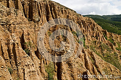 At close of the famous Stob Pyramids with unusual shape red and yellow rock formations, green bushes and trees around Stock Photo