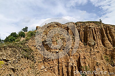 At close of the famous Stob Pyramids with unusual shape red and yellow rock formations, green bushes and trees around Stock Photo