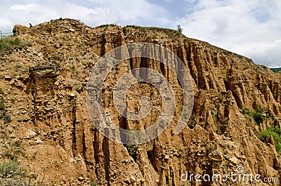 At close of the famous Stob Pyramids with unusual shape red and yellow rock formations, green bushes and trees around Stock Photo