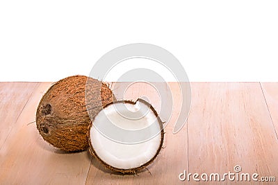 Close fresh, organic, brown coconut on a light wooden table, isolated on a white background. A tasty whole coconut. Exotic fruit. Stock Photo