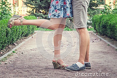 Close the legs of young men and women during a romantic date in a green garden. Stock Photo