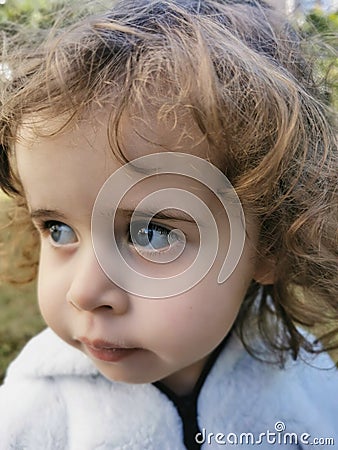 Close of Little Brazilian girl looking to the side outdoors Stock Photo