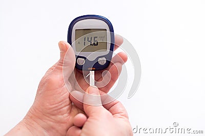 Close person checking blood sugar with glucometer and test strip at home Stock Photo