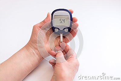 Close person checking blood sugar with glucometer and test strip at home Stock Photo