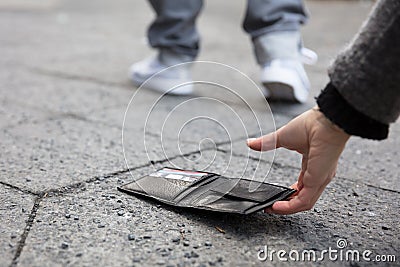 Person Picking Up A Lost Wallet Stock Photo