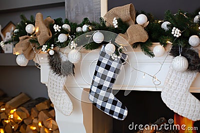 A close picture of beautifully decorated white Christmas socks hanging on fireplace waiting for presents. Christmas socks hanging Stock Photo