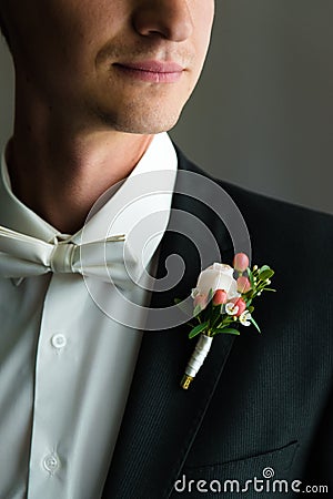 Close picture of a neat broom`s shoulder in a fine wedding suit with a nice bunch of flowers Stock Photo