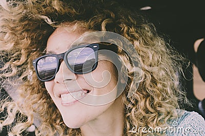 Close portrait of beautiful young adult caucasian cheerful happy woman smile and look at the road reflected on sunglasses during a Stock Photo