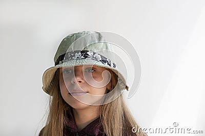 Close. The girl is 11 years old. Portrait of a cute girl with dark long hair. Dressed in a hat. Child teenager. On a white backgro Stock Photo