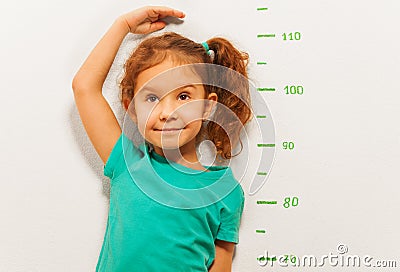 Close portrait of a girl show height on wall scale Stock Photo