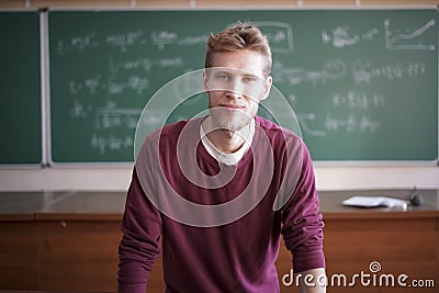 Close portrait of young bearded professor teacher in casual with blackboard with formulas behind Stock Photo