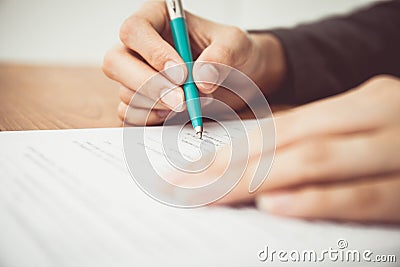 Close shot of a human hand writing contract Stock Photo