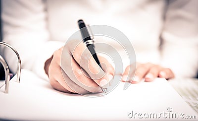 Close shot of a human hand writing something on the paper Stock Photo