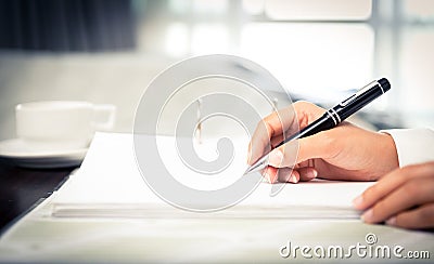 Close shot of a human hand writing something on the paper Stock Photo