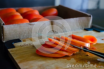 Close shot of a sliced tomatoe. Box with tomatoes on the bakground Stock Photo