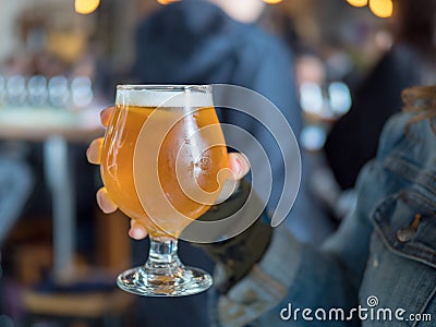 Close shot of a woman holding light beer snifter IPA Stock Photo