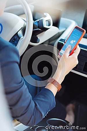 Close of a smartphone being help by female driver Stock Photo