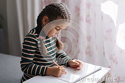 Close-up of adorable girl drawing. Creativity little girl painting at home. Stock Photo