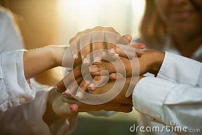 Close up of african-american and caucasian human`s hands holding on wooden table Stock Photo