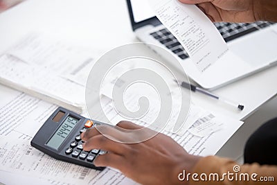 Close up african american man hand using calculator and laptop. Stock Photo