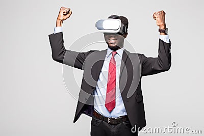 Close up of African employee wearing formal suit and goggles, experiencing virtual reality, stretching his arms up like win game. Stock Photo