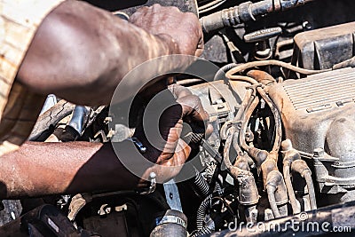 Close-up on an African man working on a broken car engine. Stock Photo