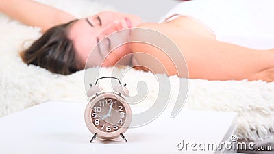 Close up alarm clock. Happy woman stretching on bed after waking up in the early morning . Have a good day. Stock Photo