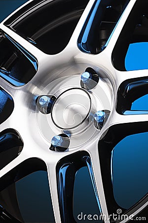 close-up of an alloy wheel and blue wheel nuts on a gradient blue background. aluminum wheel details, beautiful shiny Stock Photo