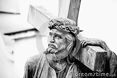 Close up ancient stone statue of Jesus Christ with cross isolated on white background. Horizontal image Stock Photo